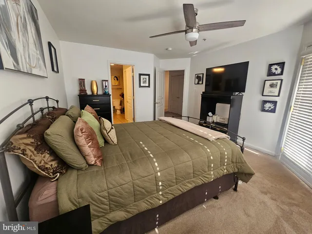 a bed sitting in a bedroom and tv on the wall
