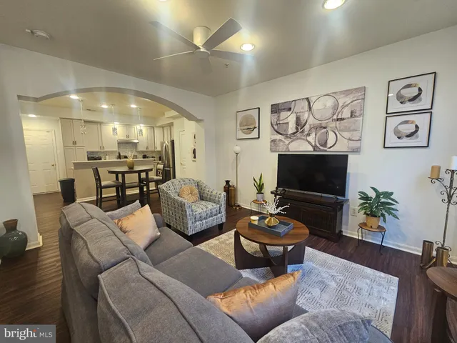 a living room with furniture a wooden floor and a flat screen tv