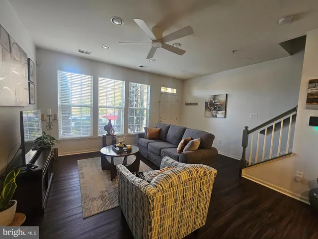 a living room with furniture wooden floor and a large window