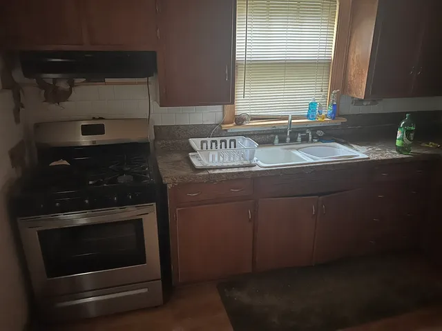 a kitchen with granite countertop a stove and a sink