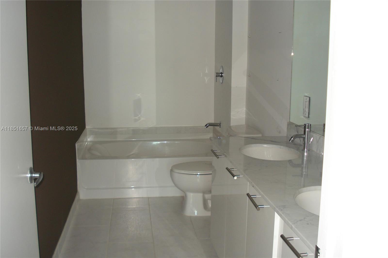 951 Brickell Avenue, Unit 1007 Miami, FL 33131 - Photo 12 of 25 a bathroom with a granite countertop toilet a sink and a shower