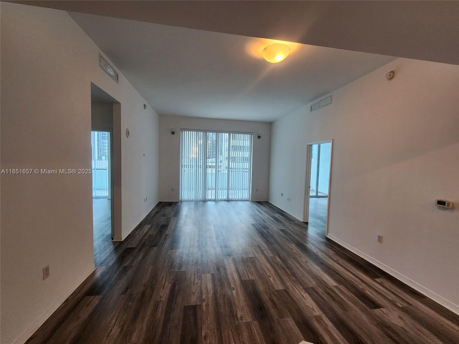 951 Brickell Avenue, Unit 1007 Miami, FL 33131 - Photo 17 of 25 a view of empty room with wooden floor and fan