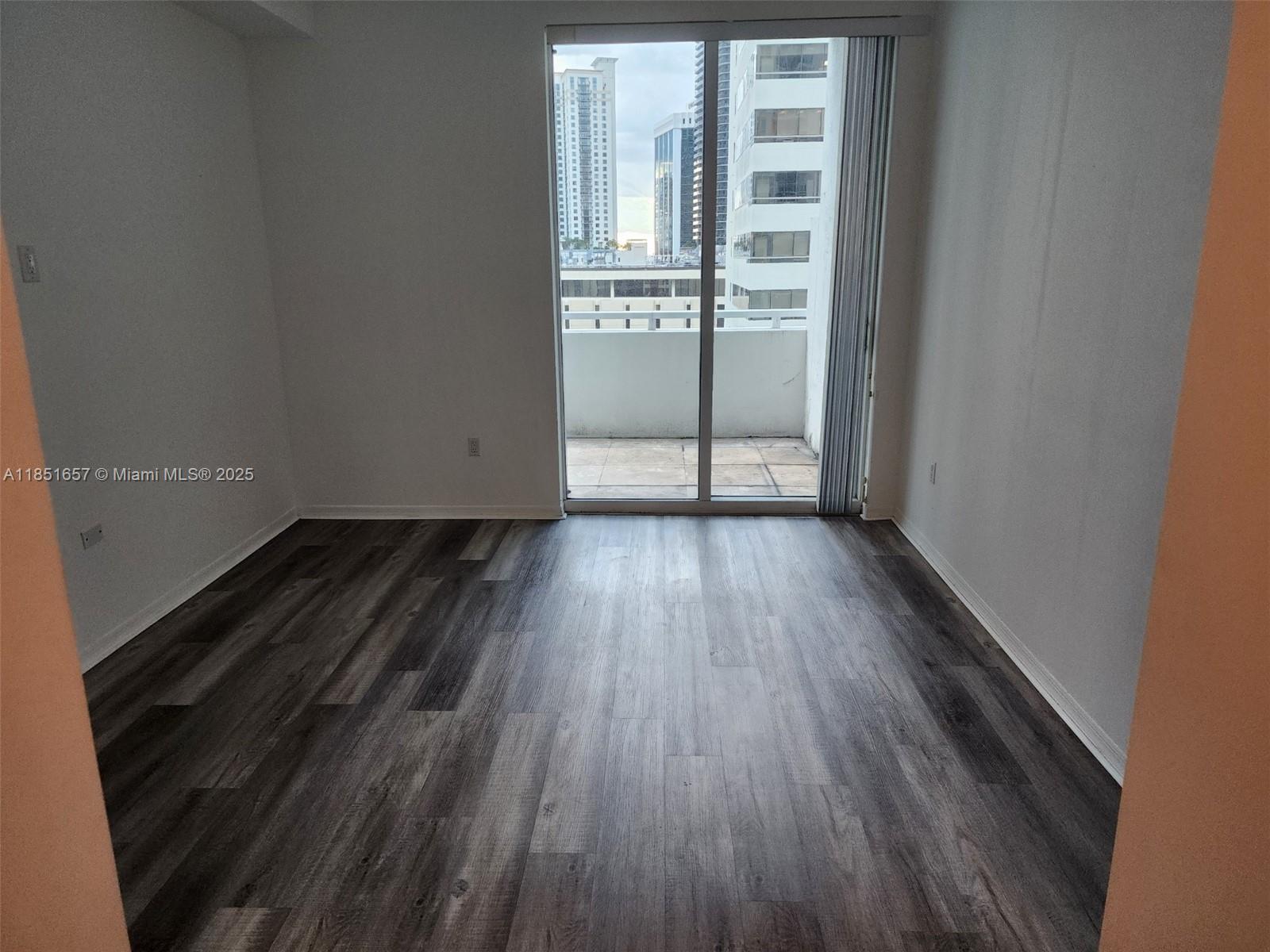 951 Brickell Avenue, Unit 1007 Miami, FL 33131 - Photo 21 of 25 a view of a room with wooden floor and windows