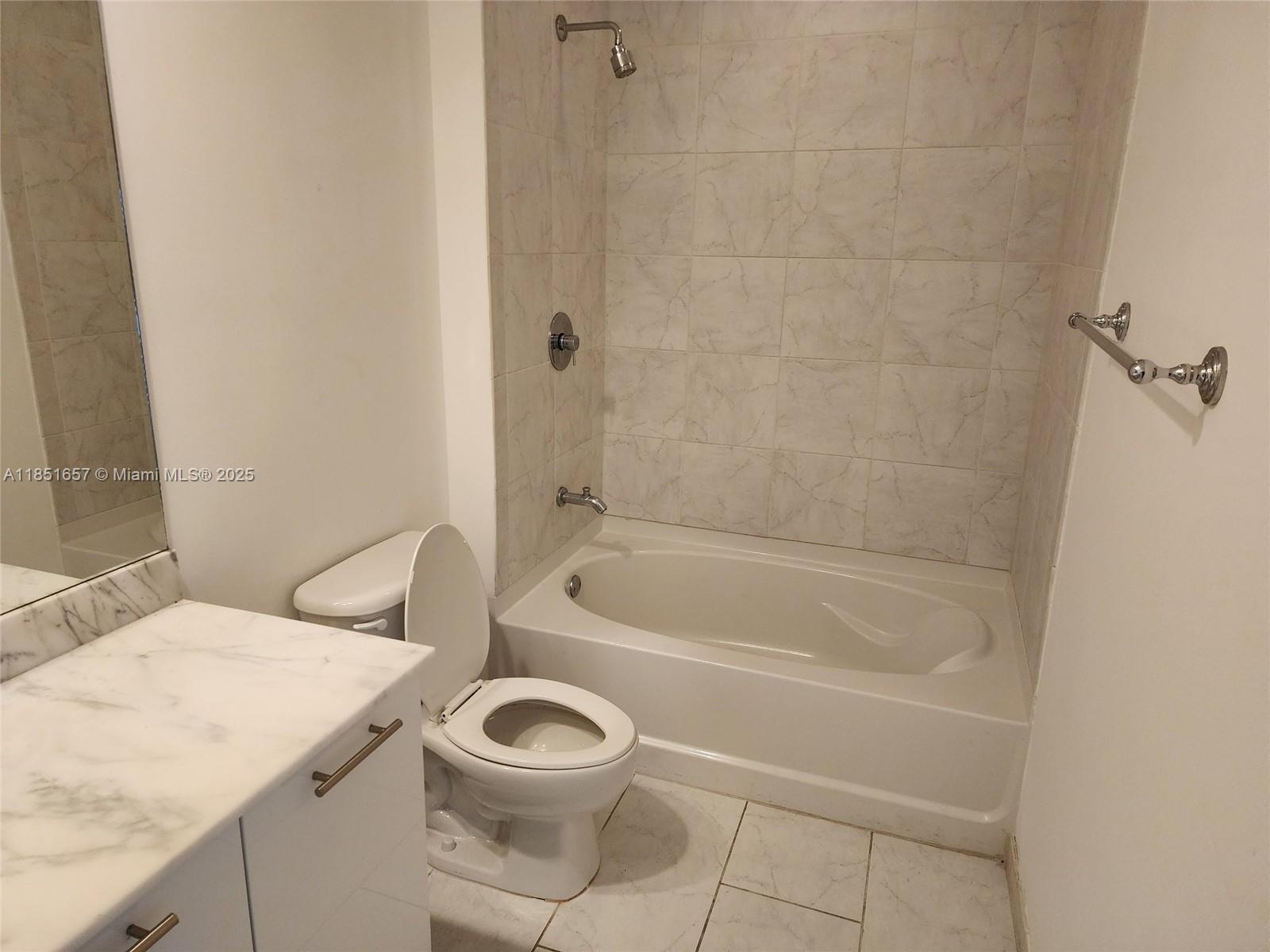 951 Brickell Avenue, Unit 1007 Miami, FL 33131 - Photo 23 of 25 a bathroom with a granite countertop toilet a sink and bathtub