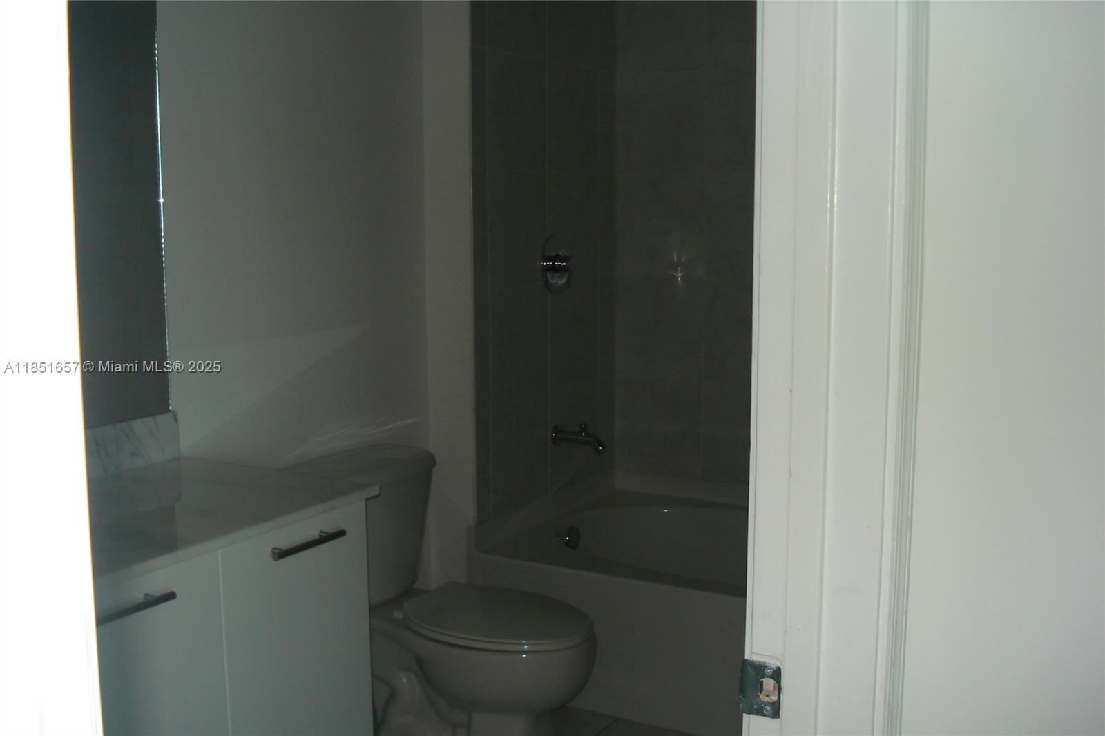 951 Brickell Avenue, Unit 1007 Miami, FL 33131 - Photo 9 of 25 a bathroom with a granite countertop toilet and a shower