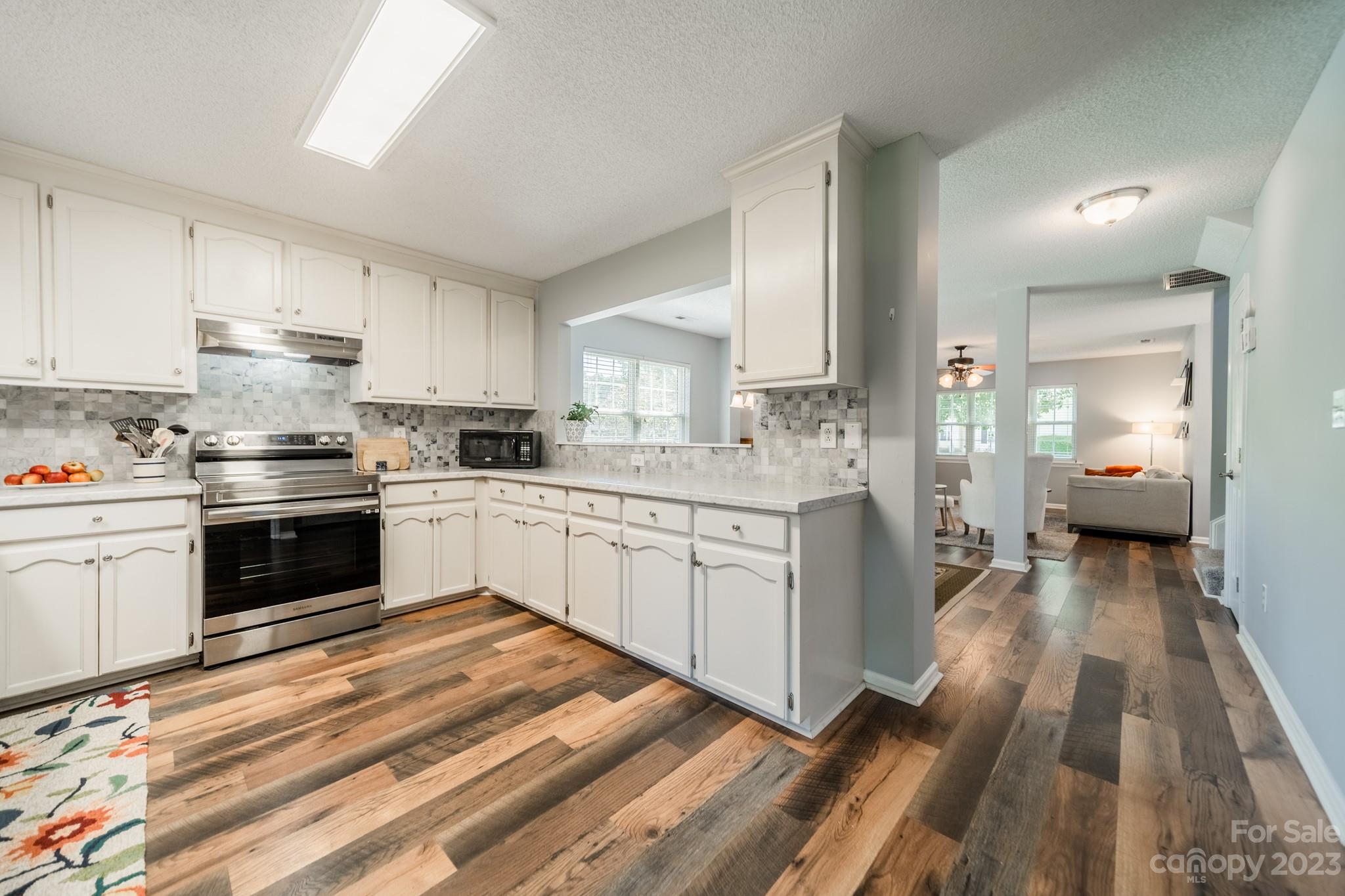 107 Howe Street Belmont, NC 28012 - Photo 11 of 35 a kitchen with a white stove top oven and white cabinets