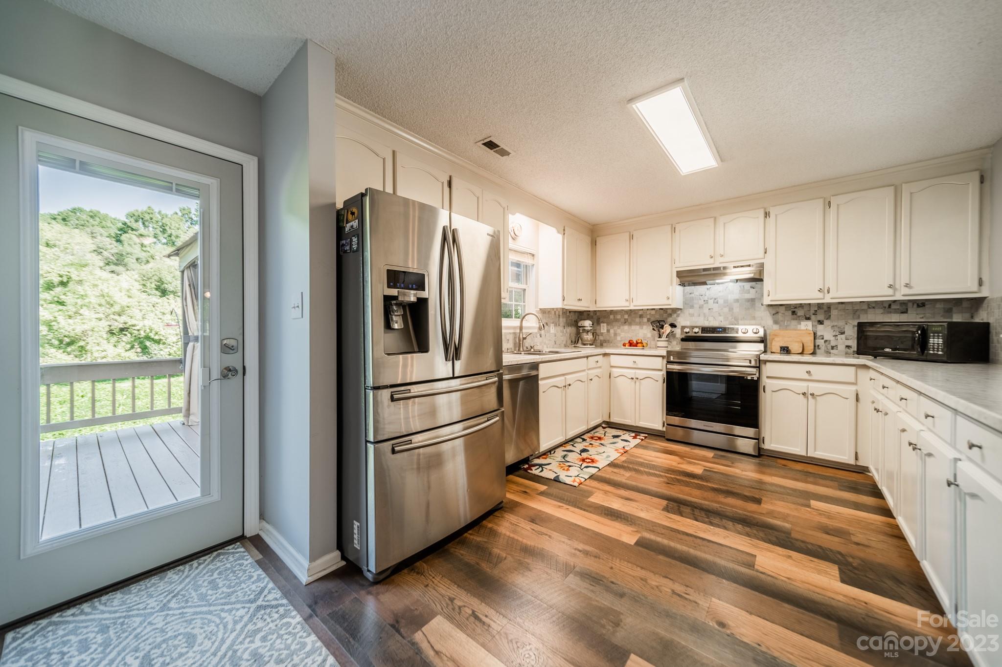 107 Howe Street Belmont, NC 28012 - Photo 10 of 35 a kitchen with white cabinets stainless steel appliances and window