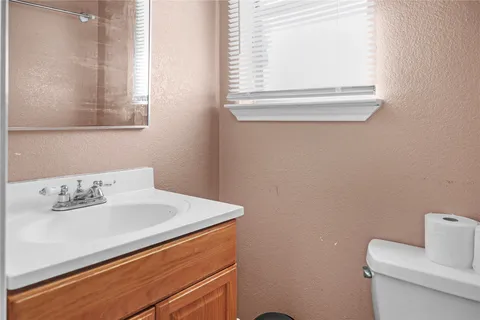 a bathroom with a sink a toilet and a window