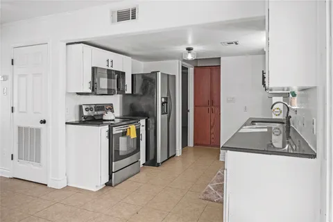 a kitchen that has a sink cabinets counter space stainless steel appliances