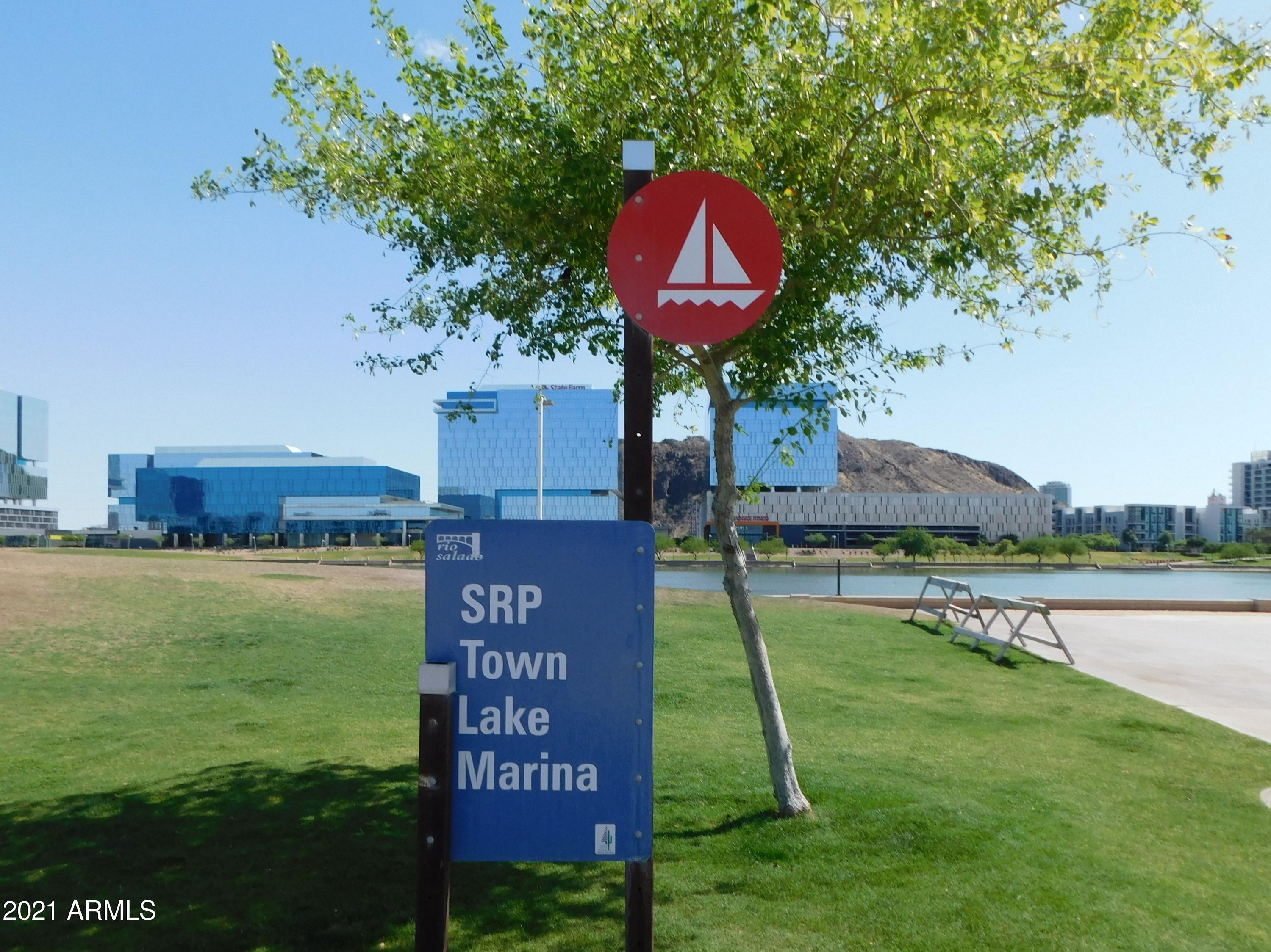 700 East Mesquite Circle, Unit R123 Tempe, AZ 85288 - Photo 20 of 28 a sign that is sitting on a lush green field near a lake