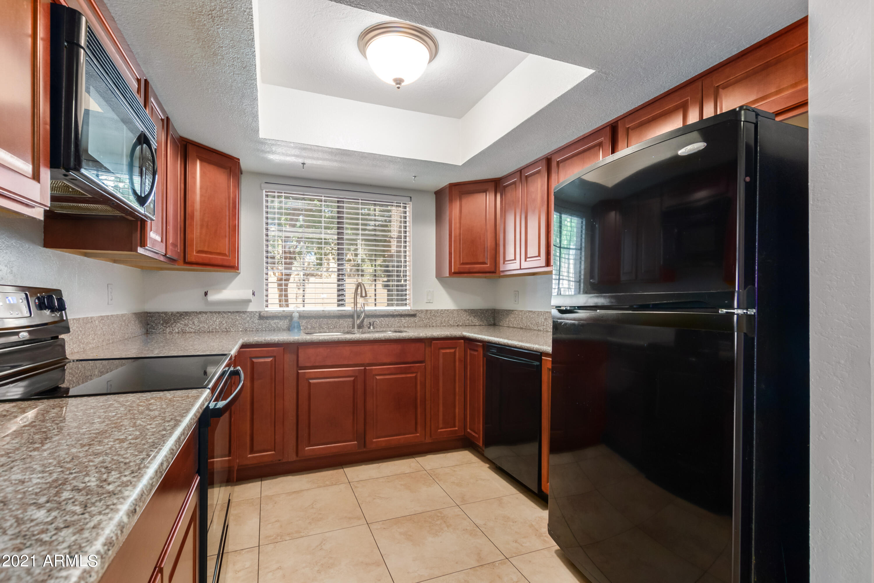 700 East Mesquite Circle, Unit R123 Tempe, AZ 85288 - Photo 2 of 28 a kitchen with a sink a microwave and cabinets
