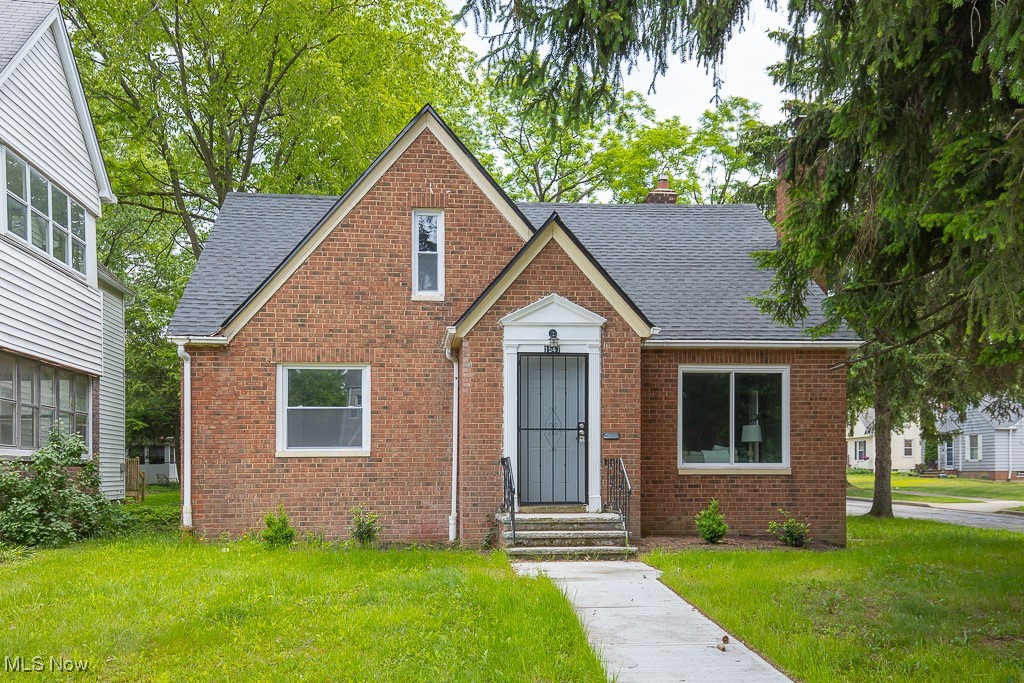 1547 Genesee Road South Euclid, OH 44121 - Photo 36 of 36 View of front of home with roof with shingles, brick siding, a front yard, and a chimney