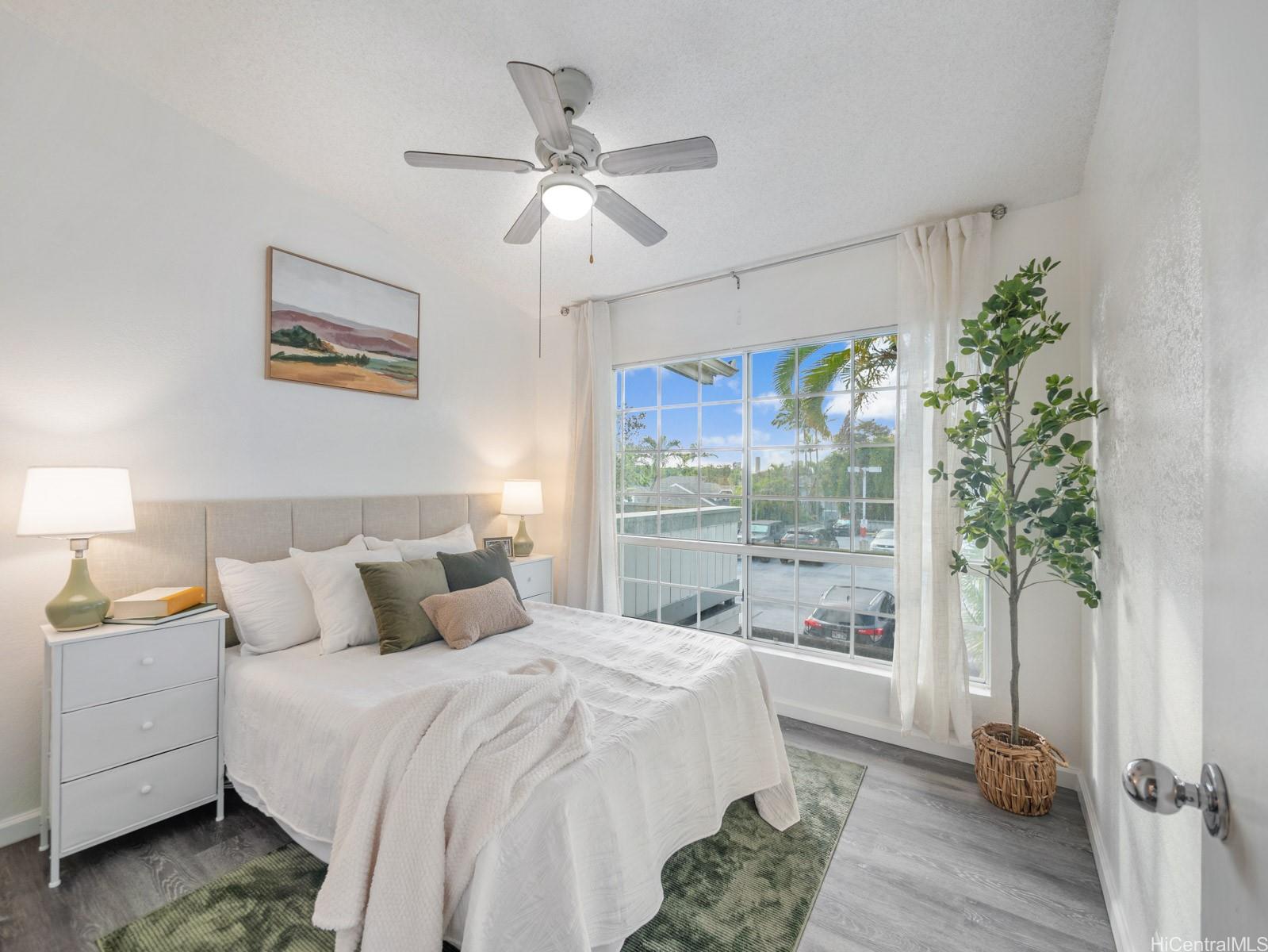 594 Mananai Place, Unit 21T Honolulu, HI 96818 - Photo 18 of 25 a bedroom with a large bed and a chandelier