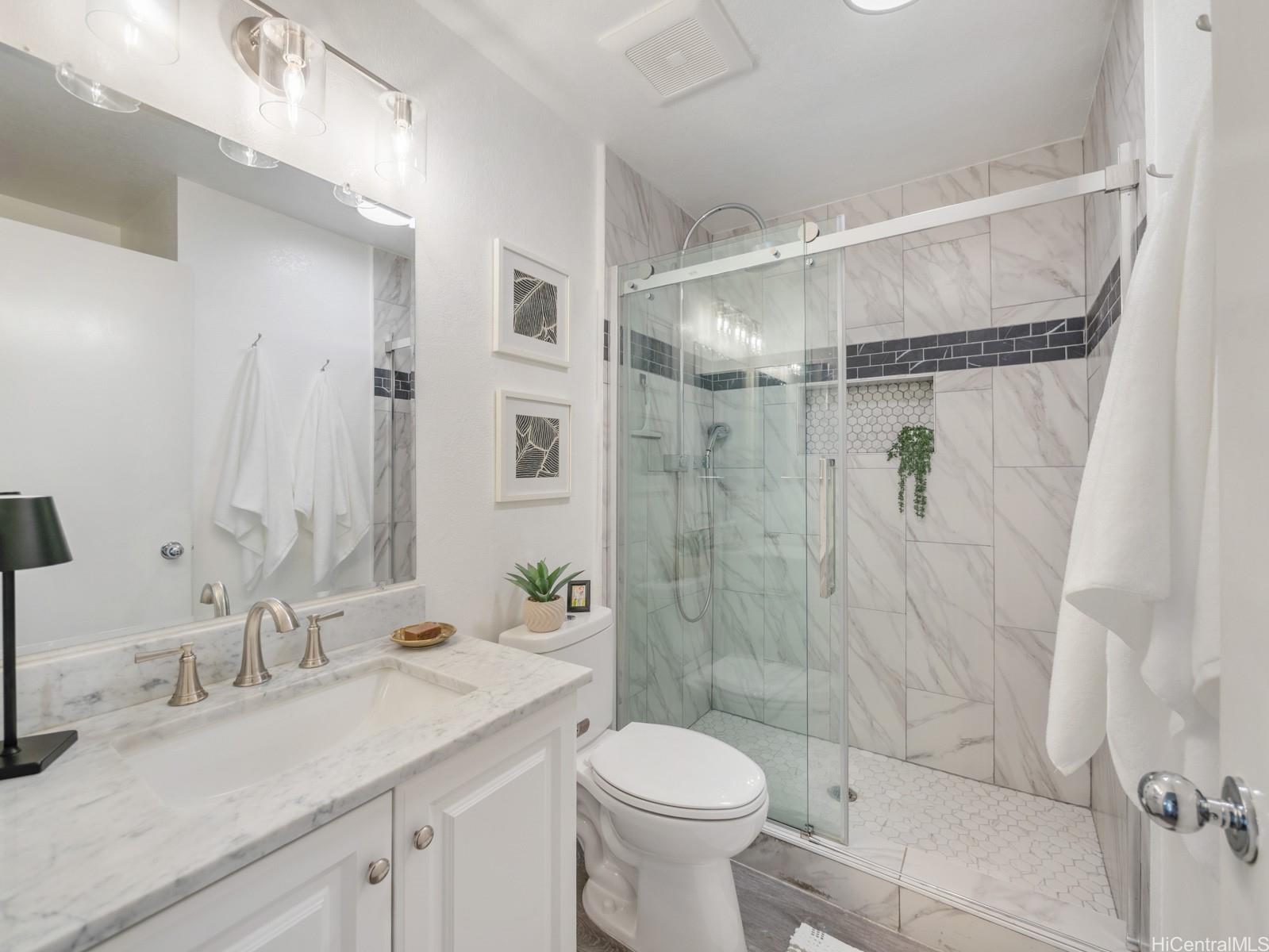 594 Mananai Place, Unit 21T Honolulu, HI 96818 - Photo 20 of 25 a bathroom with a shower sink vanity mirror and toilet
