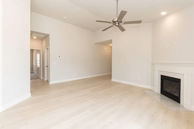 a large kitchen with granite countertop a large window and white cabinets