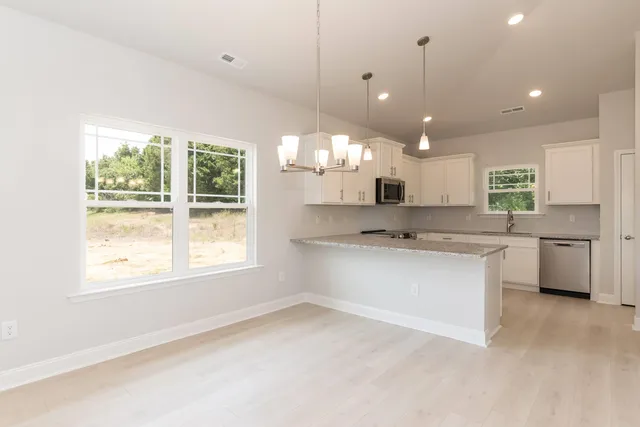 a kitchen with granite countertop white cabinets and a stove