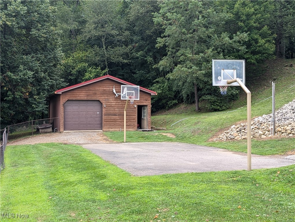 46136 Carlisle Road Lisbon, OH 44432 - Photo 20 of 48 View of front of home featuring a garage, basketball court, an outdoor structure, and a front yard