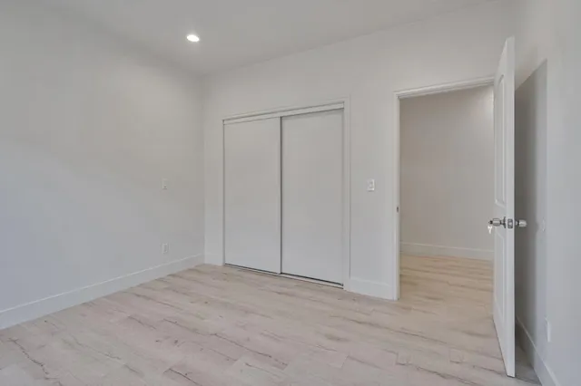 an empty room with windows and closet