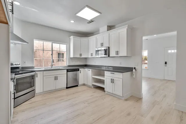 a kitchen with granite countertop a sink stainless steel appliances and cabinets