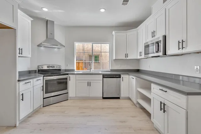 a view of an empty room with wooden floor and closet