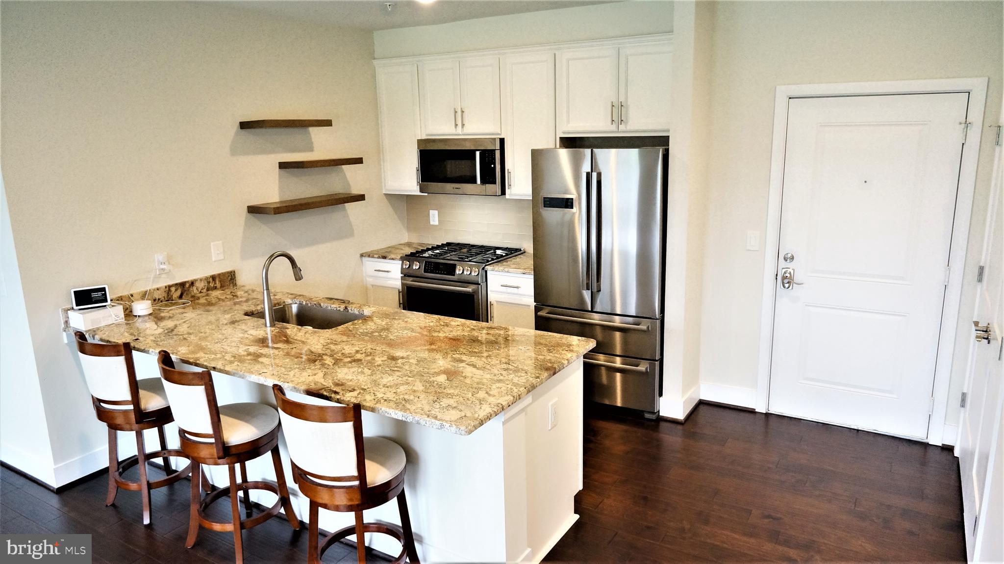 1951 Reston Vly Way, Unit 10 Reston, VA 20191 - Photo 8 of 50 a kitchen with stainless steel appliances granite countertop a stove refrigerator and microwave