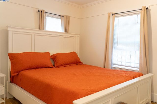 a blue bed sitting in a bedroom next to a window