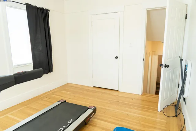 a view of a room with wooden floor and a bathroom