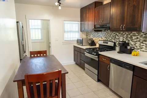 a kitchen with stainless steel appliances a stove a sink a refrigerator and cabinets