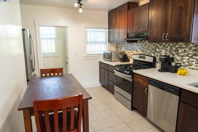 a kitchen with stainless steel appliances a stove a sink a refrigerator and cabinets