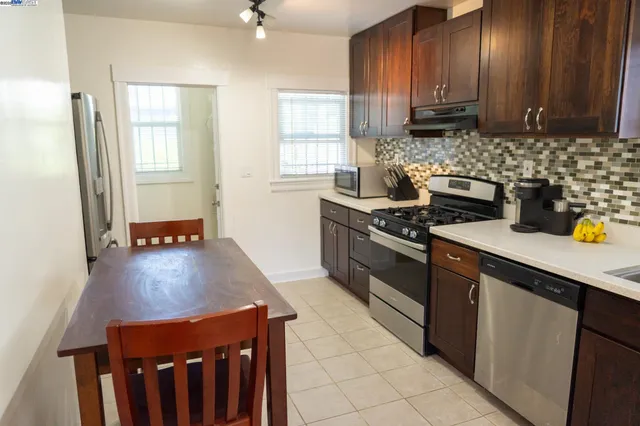 a kitchen with stainless steel appliances a stove a sink a refrigerator and cabinets