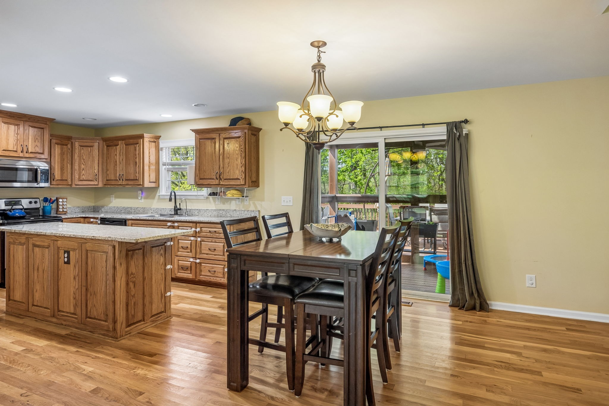 1548 Heller Ridge Spring Hill, TN 37174 - Photo 12 of 73 a kitchen with stainless steel appliances granite countertop a stove top oven a sink dishwasher a dining table and chairs with wooden floor