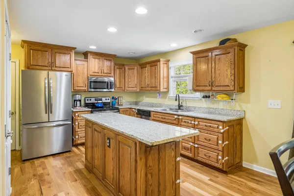 a kitchen with granite countertop a sink a counter space and stainless steel appliances