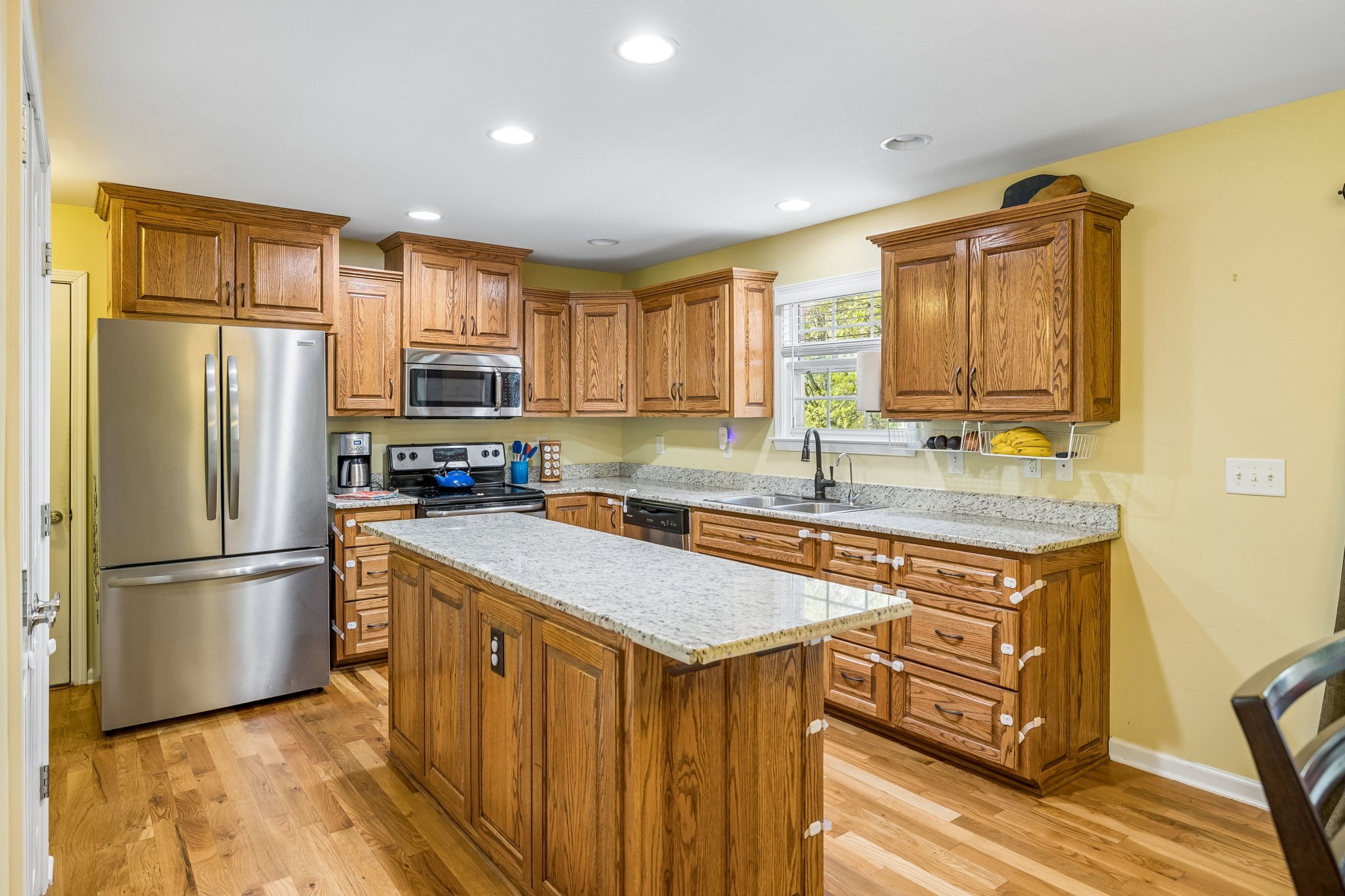 1548 Heller Ridge Spring Hill, TN 37174 - Photo 18 of 73 a kitchen with stainless steel appliances granite countertop a refrigerator a stove a sink dishwasher and microwave with wooden floor