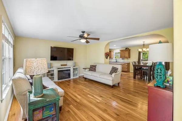 a kitchen with stainless steel appliances granite countertop a stove top oven a sink dishwasher a dining table and chairs with wooden floor