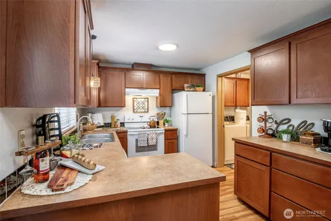 a kitchen with stainless steel appliances granite countertop a refrigerator stove top oven a sink and cabinets