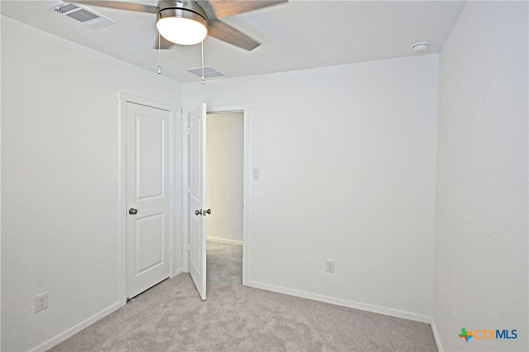 11806 Bluebell Ridge Converse, TX 78109 - Photo 19 of 20 an empty room with a chandelier fan and closet
