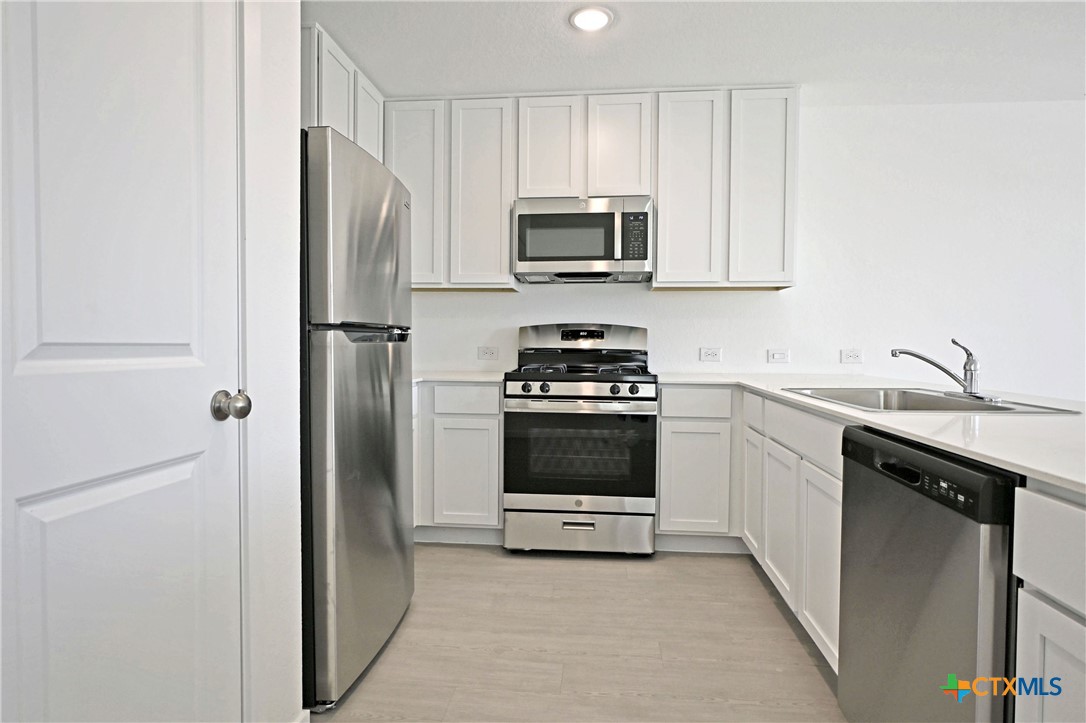 11806 Bluebell Ridge Converse, TX 78109 - Photo 5 of 20 a kitchen with stainless steel appliances a refrigerator sink and microwave