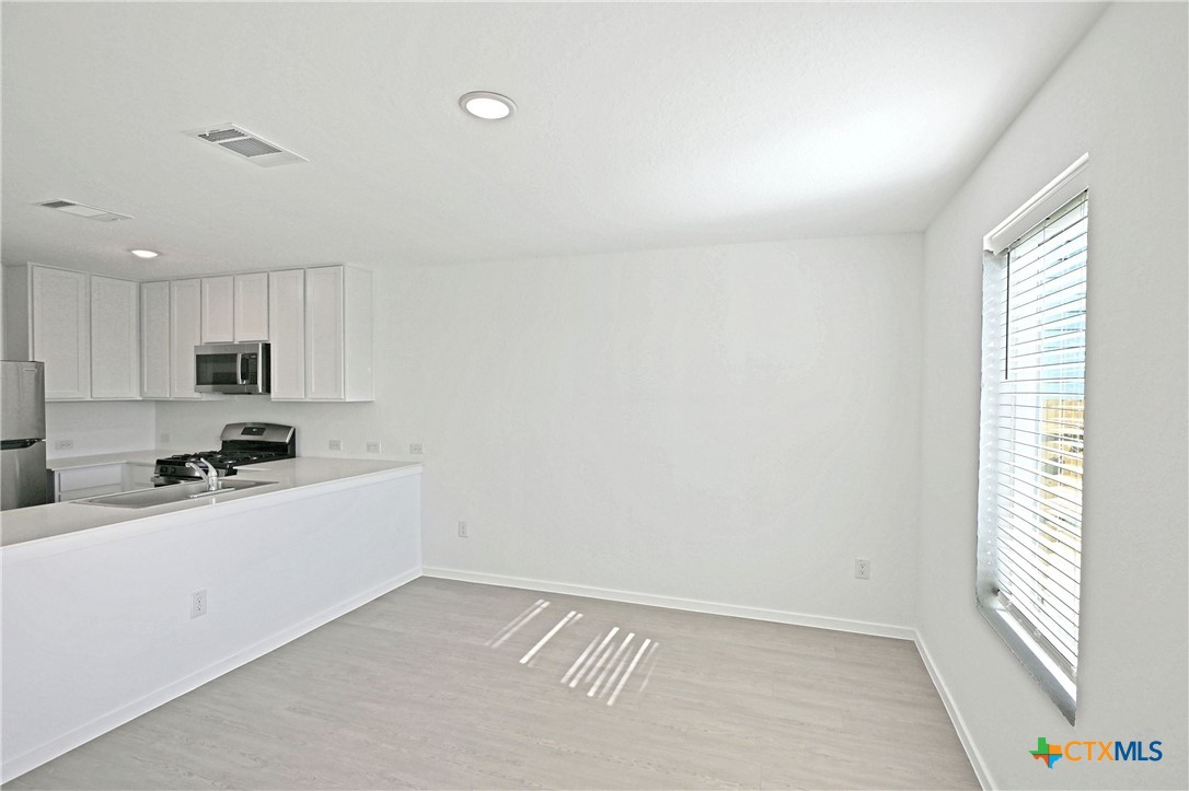 11806 Bluebell Ridge Converse, TX 78109 - Photo 8 of 20 a kitchen with stainless steel appliances a sink a stove a refrigerator and cabinets