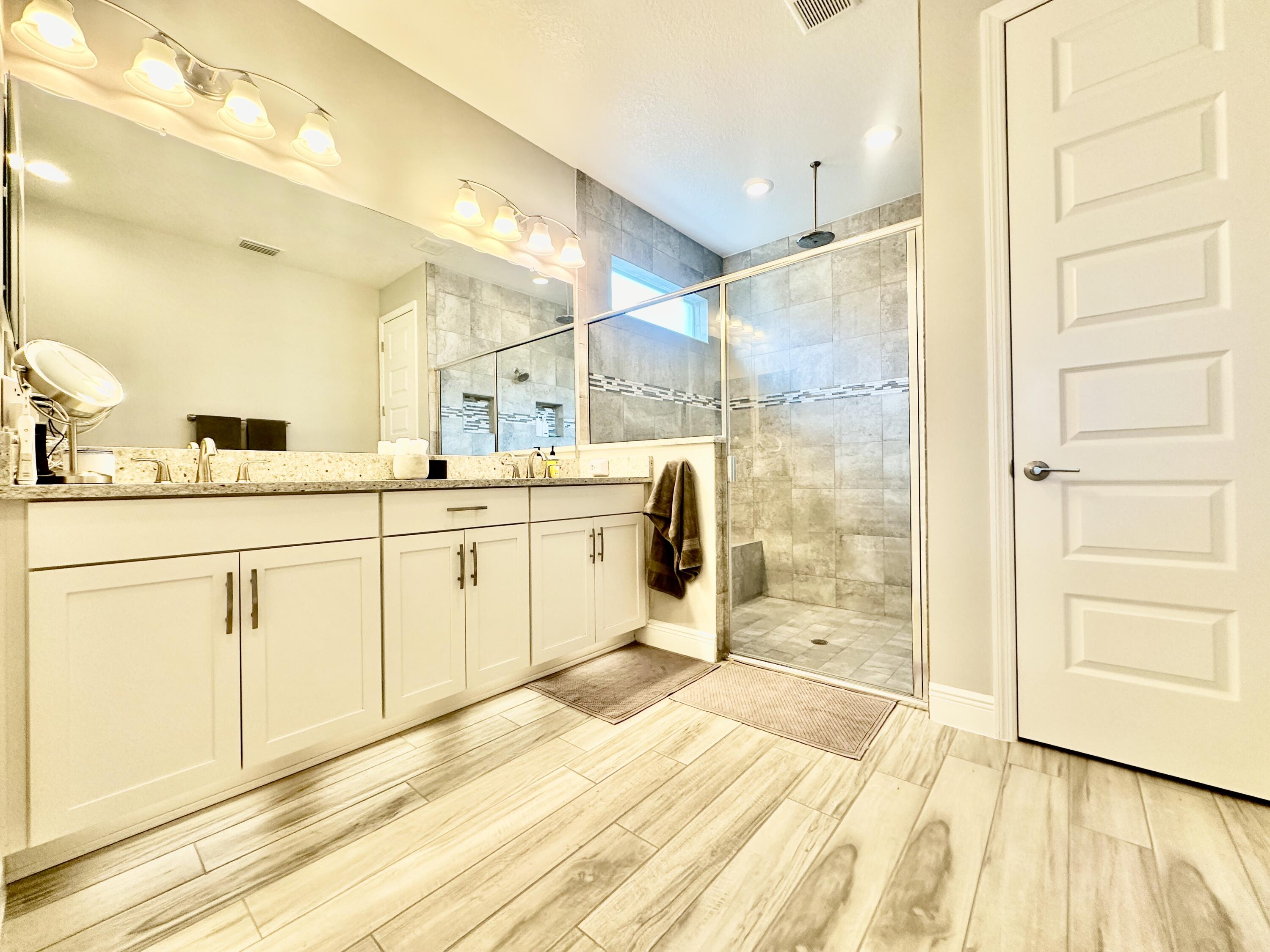 3044 Trasona Drive Melbourne, FL 32940 - Photo 18 of 36 a bathroom with a sink a mirror and a shower