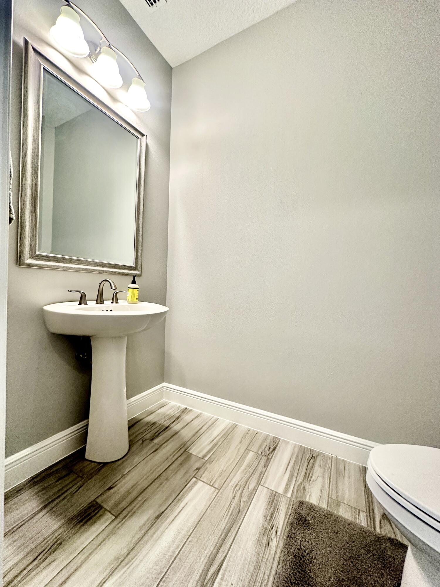 3044 Trasona Drive Melbourne, FL 32940 - Photo 27 of 36 a bathroom with a sink mirror and toilet