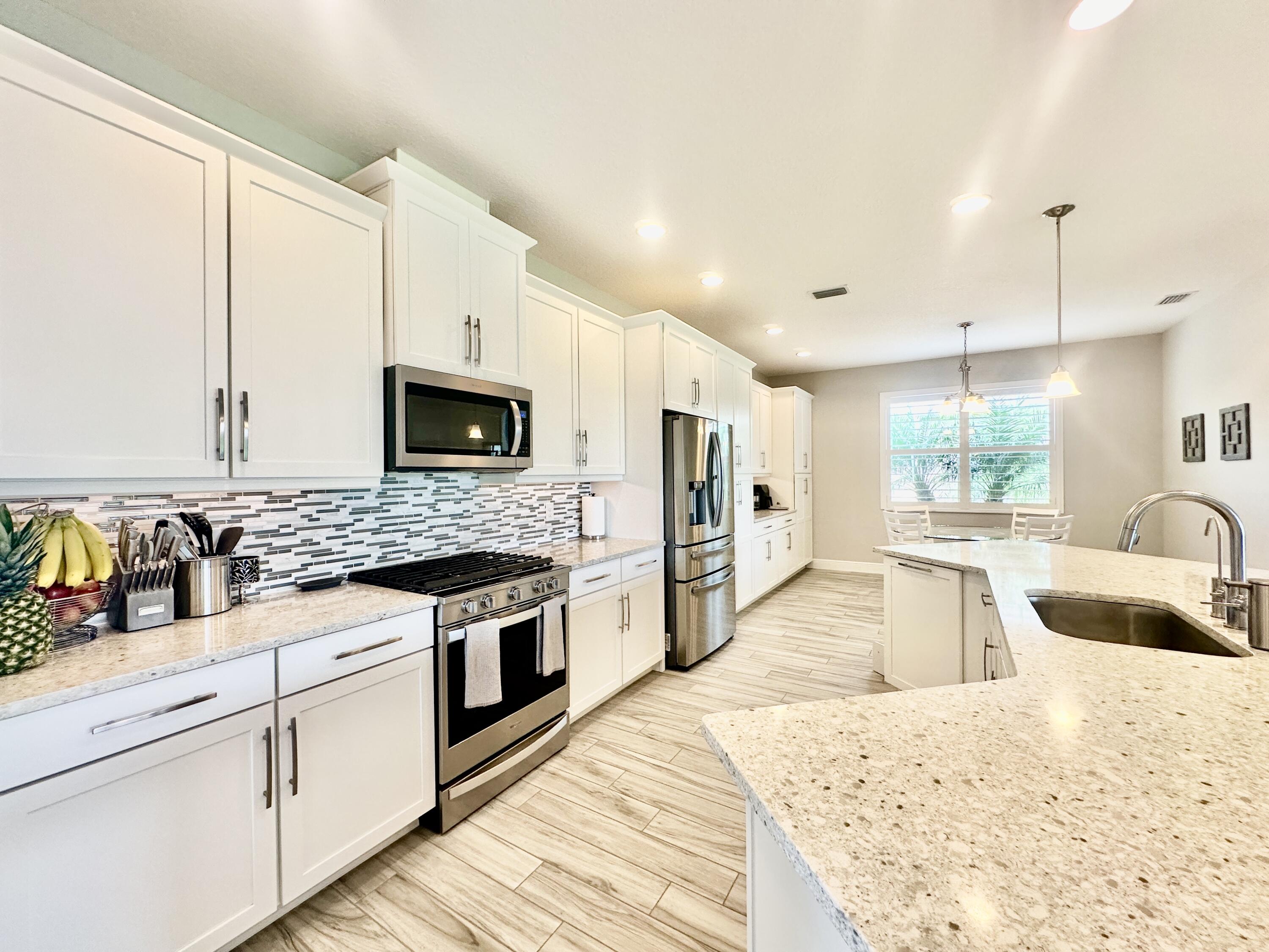 3044 Trasona Drive Melbourne, FL 32940 - Photo 7 of 36 a kitchen with stainless steel appliances granite countertop a stove a sink and a microwave