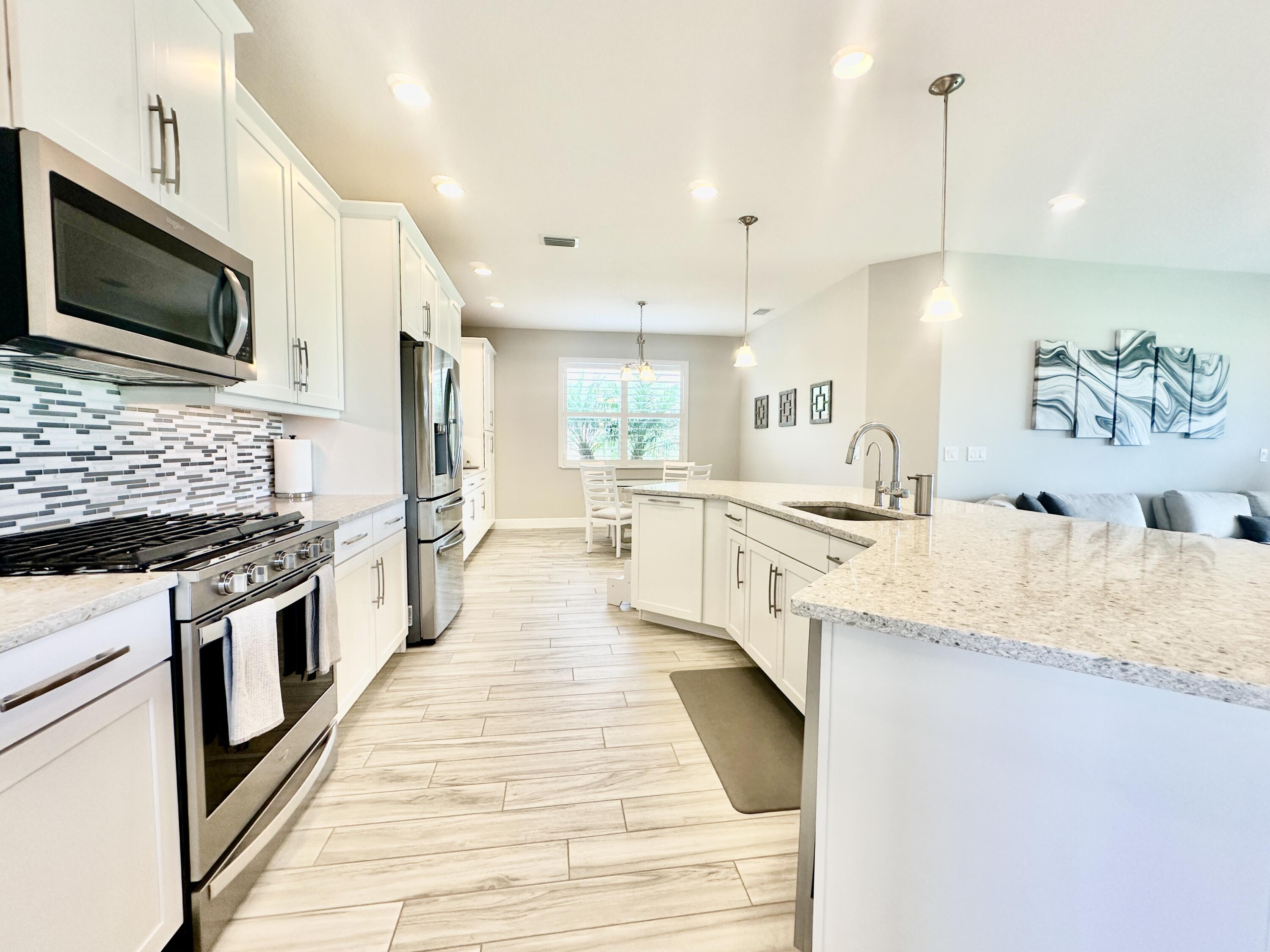 3044 Trasona Drive Melbourne, FL 32940 - Photo 8 of 36 a large kitchen with granite countertop a sink and a stove top oven