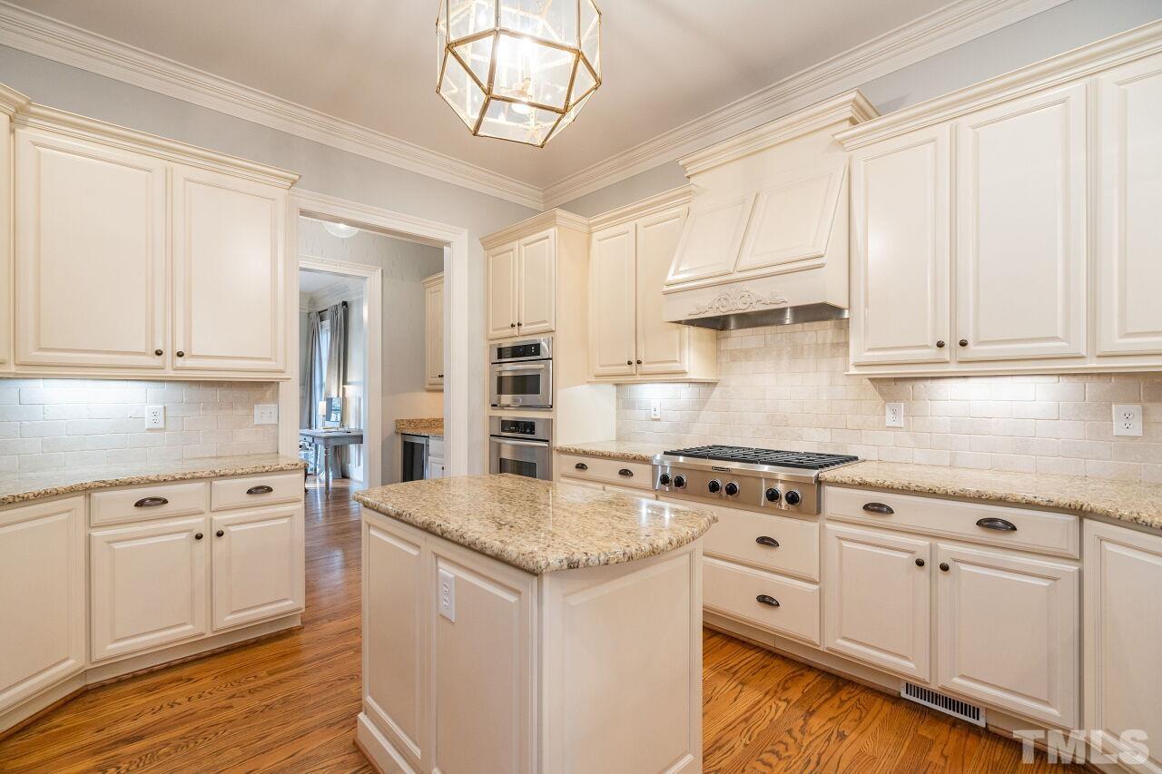 3056 Lewis Farm Road Raleigh, NC 27607 - Photo 15 of 43 a kitchen with granite countertop white cabinets and white appliances