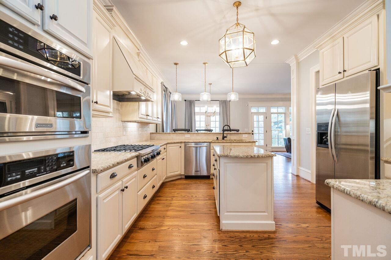 3056 Lewis Farm Road Raleigh, NC 27607 - Photo 17 of 43 a kitchen with white cabinets and stainless steel appliances