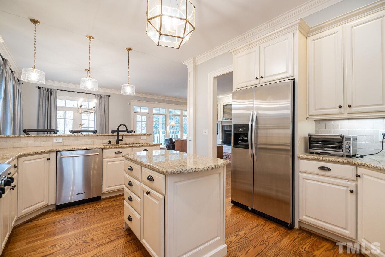 3056 Lewis Farm Road Raleigh, NC 27607 - Photo 18 of 43 a kitchen with white cabinets and stainless steel appliances