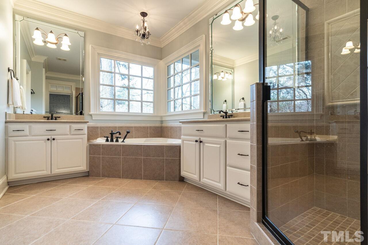 3056 Lewis Farm Road Raleigh, NC 27607 - Photo 25 of 43 a large white bathroom with a tub sink shower and mirror