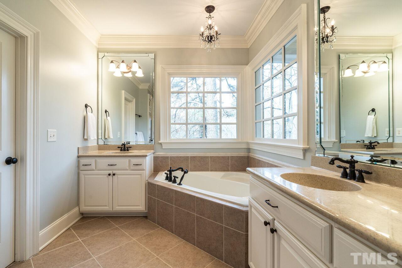 3056 Lewis Farm Road Raleigh, NC 27607 - Photo 26 of 43 a bathroom with a granite countertop sink mirror bathtub and double