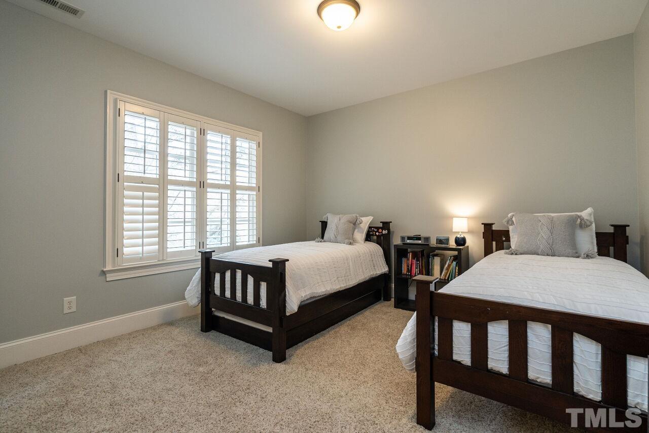 3056 Lewis Farm Road Raleigh, NC 27607 - Photo 28 of 43 a bedroom with a bed window and a table in it