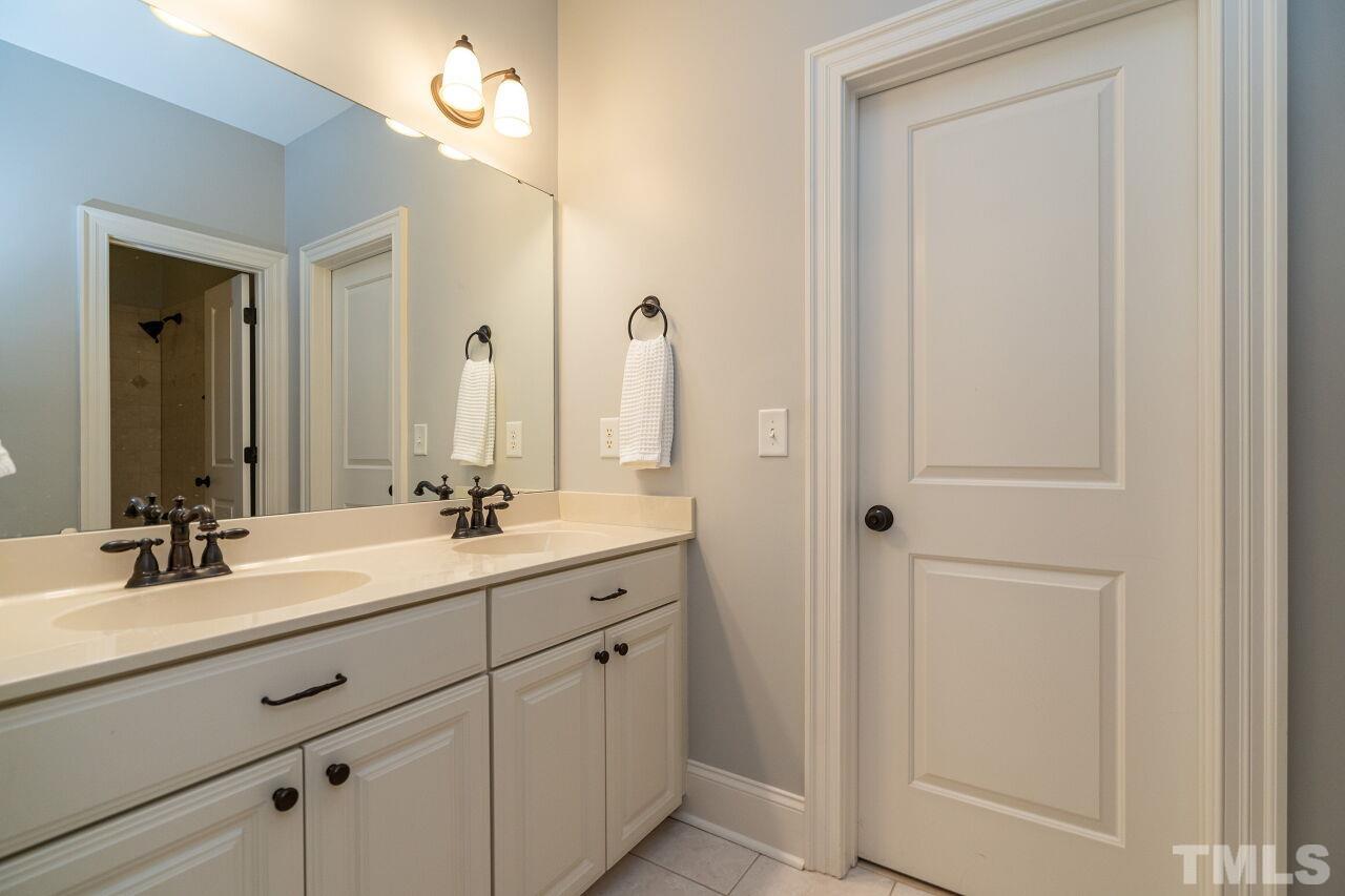 3056 Lewis Farm Road Raleigh, NC 27607 - Photo 29 of 43 a bathroom with a double vanity sink and a mirror