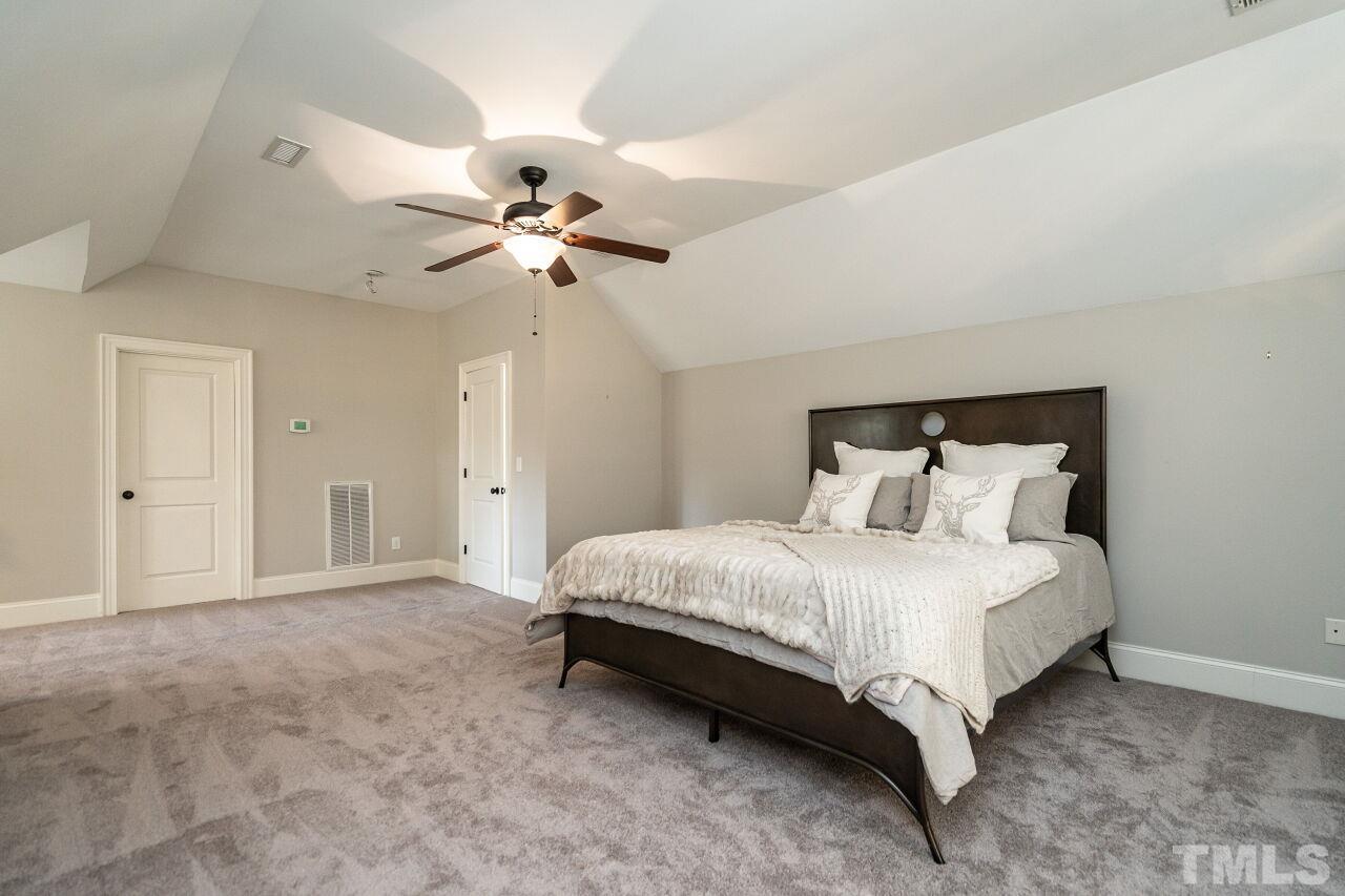 3056 Lewis Farm Road Raleigh, NC 27607 - Photo 32 of 43 a spacious bedroom with a bed and a ceiling fan